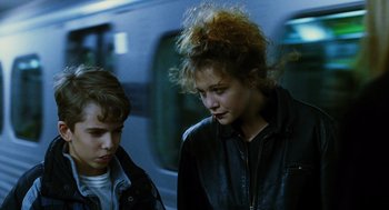 Movie still from “Mimic” (1997), directed by Guillermo del Toro – Two people standing next to each other near a train; Close Up shot, Over the shoulder angle