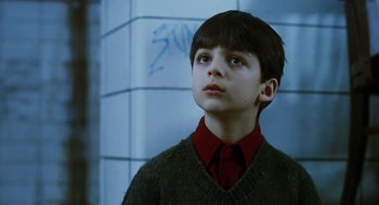 Movie still from “Mimic” (1997), directed by Guillermo del Toro – A boy in a red shirt and a green sweater looking up; Close Up shot, Low angle