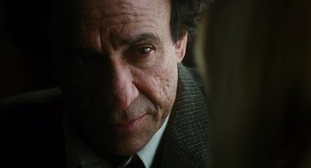 Movie still from “Mimic” (1997), directed by Guillermo del Toro – An older man wearing a suit and tie; Close Up shot, Over the shoulder angle
