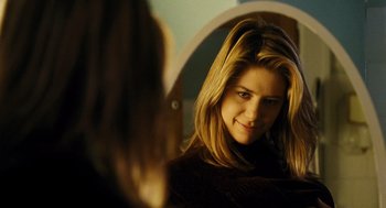 Movie still from “Mimic” (1997), directed by Guillermo del Toro – A woman looking into a mirror while standing in front of a mirror; Close Up shot, Over the shoulder angle