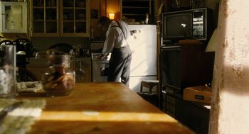 Movie still from “Mimic” (1997), directed by Guillermo del Toro – An old man in a kitchen with an oven and a refrigerator; Medium shot, Low angle