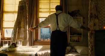 Movie still from “Mimic” (1997), directed by Guillermo del Toro – A man standing in front of a window with his arms outstretched; Medium shot, Low angle