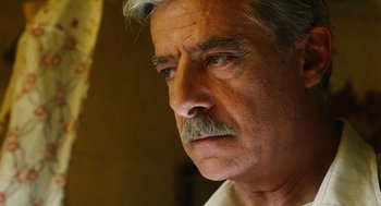 Movie still from “Mimic” (1997), directed by Guillermo del Toro – An older man with a mustache looking to his left; Close Up shot, Low angle