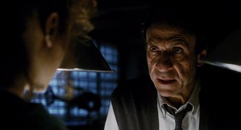 Movie still from “Mimic” (1997), directed by Guillermo del Toro – A man in a vest and tie looking at another man in a hat; Close Up shot, Low angle