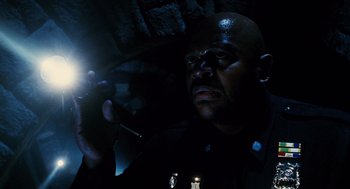 Movie still from “Mimic” (1997), directed by Guillermo del Toro – A man holding a cell phone in the dark; Close Up shot, High angle
