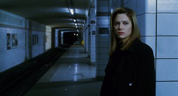 Movie still from “Mimic” (1997), directed by Guillermo del Toro – A woman standing in a subway tunnel looking at the camera; Medium shot, Low angle