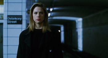 Movie still from “Mimic” (1997), directed by Guillermo del Toro – A woman in a black coat standing in a tunnel; Close Up shot, Low angle