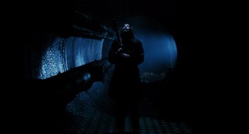 Movie still from “Mimic” (1997), directed by Guillermo del Toro – A man holding a gun standing in a dark tunnel; Wide shot, Low angle