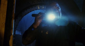 Movie still from “Mimic” (1997), directed by Guillermo del Toro – A man is holding a flashlight in his hand; Close Up shot, Low angle