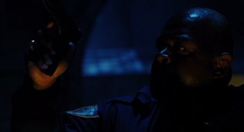 Movie still from “Mimic” (1997), directed by Guillermo del Toro – A police officer sitting in the dark with a cell phone; Close Up shot, Low angle