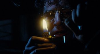 Movie still from “Mimic” (1997), directed by Guillermo del Toro – A man holding a lit candle in a dark room; Close Up shot, Low angle