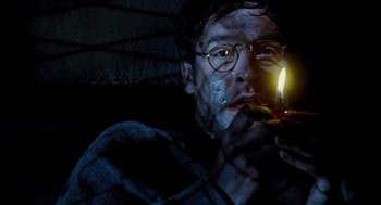 Movie still from “Mimic” (1997), directed by Guillermo del Toro – A man with glasses is lighting a candle; Close Up shot, Low angle