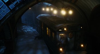 Movie still from “Mimic” (1997), directed by Guillermo del Toro – A train traveling under a bridge at night time; Wide shot, High angle