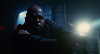 Movie still from “Mimic” (1997), directed by Guillermo del Toro – A man in a dark room holding a flashlight; Close Up shot, Low angle