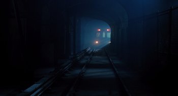 Movie still from “Mimic” (1997), directed by Guillermo del Toro – A train traveling down train tracks through a tunnel; Extreme Wide shot, High angle