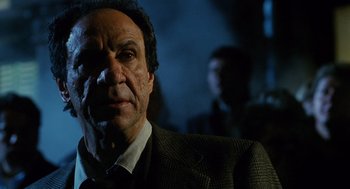 Movie still from “Mimic” (1997), directed by Guillermo del Toro – A person wearing a suit and tie; Close Up shot, Low angle