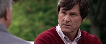 Movie still from “Miracle” (2004), directed by Gavin O'Connor – An older man wearing a red sweater and a white shirt; Close Up shot, Over the shoulder angle