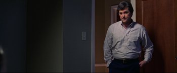 Movie still from “Miracle” (2004), directed by Gavin O'Connor – A man standing in front of a wall in a room; Medium shot, Over the shoulder angle