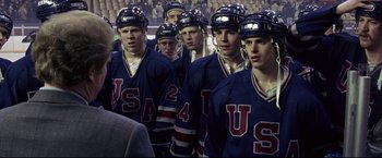 Movie still from “Miracle” (2004), directed by Gavin O'Connor – A group of hockey players standing together in a stadium; Medium shot, Over the shoulder angle