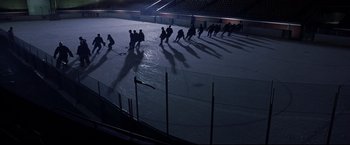 Movie still from “Miracle” (2004), directed by Gavin O'Connor – A group of men playing a game of ice hockey on an ice rink at night; Extreme Wide shot, High angle