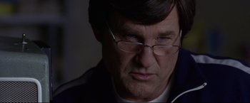 Movie still from “Miracle” (2004), directed by Gavin O'Connor – A person wearing glasses and a jacket; Close Up shot, Over the shoulder angle