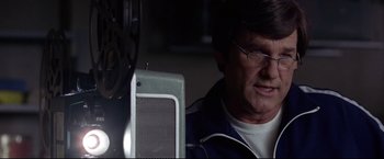 Movie still from “Miracle” (2004), directed by Gavin O'Connor – An older man wearing glasses and a blue jacket; Close Up shot, Low angle