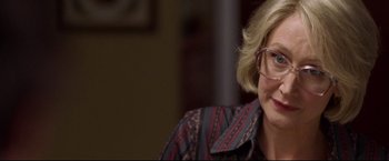 Movie still from “Miracle” (2004), directed by Gavin O'Connor – A person wearing glasses and smiling; Close Up shot, Over the shoulder angle