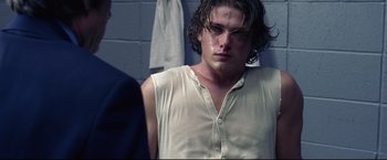 Movie still from “Miracle” (2004), directed by Gavin O'Connor – A man with long hair and a white tank top; Close Up shot, Over the shoulder angle