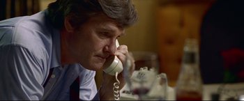 Movie still from “Miracle” (2004), directed by Gavin O'Connor – A man sitting at a table talking on a phone; Close Up shot, Low angle