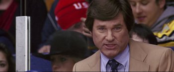 Movie still from “Miracle” (2004), directed by Gavin O'Connor – A man in a tan suit and a red hat; Close Up shot, Low angle