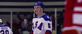 Movie still from “Miracle” (2004), directed by Gavin O'Connor – A hockey player in a white and blue uniform; Medium shot, Low angle