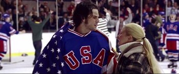 Movie still from “Miracle” (2004), directed by Gavin O'Connor – A man in a hockey jersey is talking to a woman; Medium shot, Over the shoulder angle