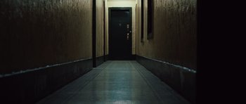 Movie still from “Miracle at St. Anna” (2008), directed by Spike Lee – A dark hallway with a door and a light on the wall; Wide shot, Low angle