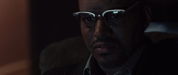 Movie still from “Miracle at St. Anna” (2008), directed by Spike Lee – A person wearing glasses; Close Up shot, Over the shoulder angle