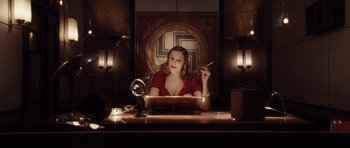 Movie still from “Miracle at St. Anna” (2008), directed by Spike Lee – A woman sitting in front of a laptop computer on top of a desk; Medium shot, High angle