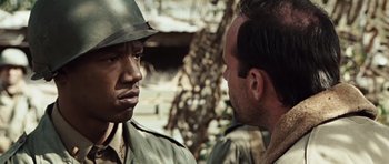 Movie still from “Miracle at St. Anna” (2008), directed by Spike Lee – A man in a hat talking to another man in a hat; Close Up shot, Over the shoulder angle