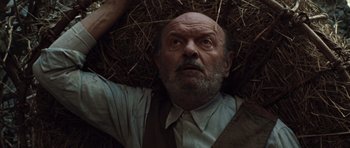 Movie still from “Miracle at St. Anna” (2008), directed by Spike Lee – An older man laying in a pile of hay; Close Up shot, Overhead angle