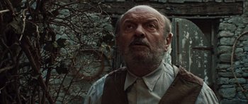 Movie still from “Miracle at St. Anna” (2008), directed by Spike Lee – An old man with a beard and mustache looking up; Close Up shot, Low angle