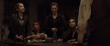 Movie still from “Miracle at St. Anna” (2008), directed by Spike Lee – A group of people sitting around a table; Medium shot, Low angle