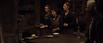 Movie still from “Miracle at St. Anna” (2008), directed by Spike Lee – A group of people standing around a table; Medium shot, Over the shoulder angle