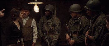 Movie still from “Miracle at St. Anna” (2008), directed by Spike Lee – A group of men standing next to each other holding guns; Medium shot, Over the shoulder angle