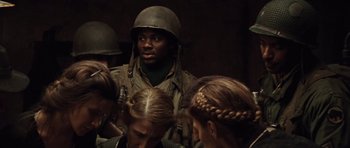 Movie still from “Miracle at St. Anna” (2008), directed by Spike Lee – A group of people in military uniforms gathered around a man; Close Up shot, Over the shoulder angle