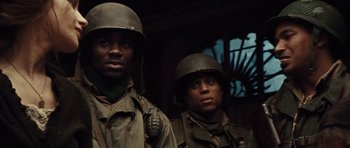 Movie still from “Miracle at St. Anna” (2008), directed by Spike Lee – Two men in military fatigues and helmets standing next to each other; Close Up shot, Low angle