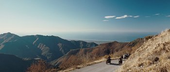 Movie still from “Miracle at St. Anna” (2008), directed by Spike Lee – Two people riding motorcycles on a mountain side road; Extreme Wide shot, High angle