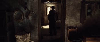 Movie still from “Miracle at St. Anna” (2008), directed by Spike Lee – A man standing in a doorway in the dark; Wide shot, Over the shoulder angle