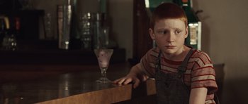 Movie still from “Miracle at St. Anna” (2008), directed by Spike Lee – A young boy sitting at a table next to a glass of ice cream; Close Up shot, Over the shoulder angle