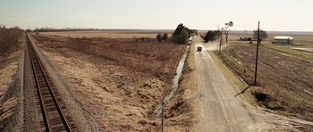 Movie still from “Miracle at St. Anna” (2008), directed by Spike Lee – A car driving down a dirt road next to a field; Extreme Wide shot, High angle