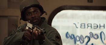 Movie still from “Miracle at St. Anna” (2008), directed by Spike Lee – A man holding a rifle in a room; Close Up shot, Over the shoulder angle