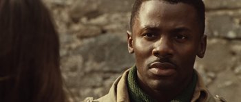Movie still from “Miracle at St. Anna” (2008), directed by Spike Lee – A person wearing a jacket and a scarf; Close Up shot, Over the shoulder angle