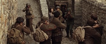 Movie still from “Miracle at St. Anna” (2008), directed by Spike Lee – A group of people standing next to each other on a street; Wide shot, Over the shoulder angle